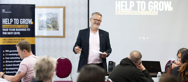 Help to Grow Management session at Cardiff Metropolitan University. Man standing in room presenting to businesses.